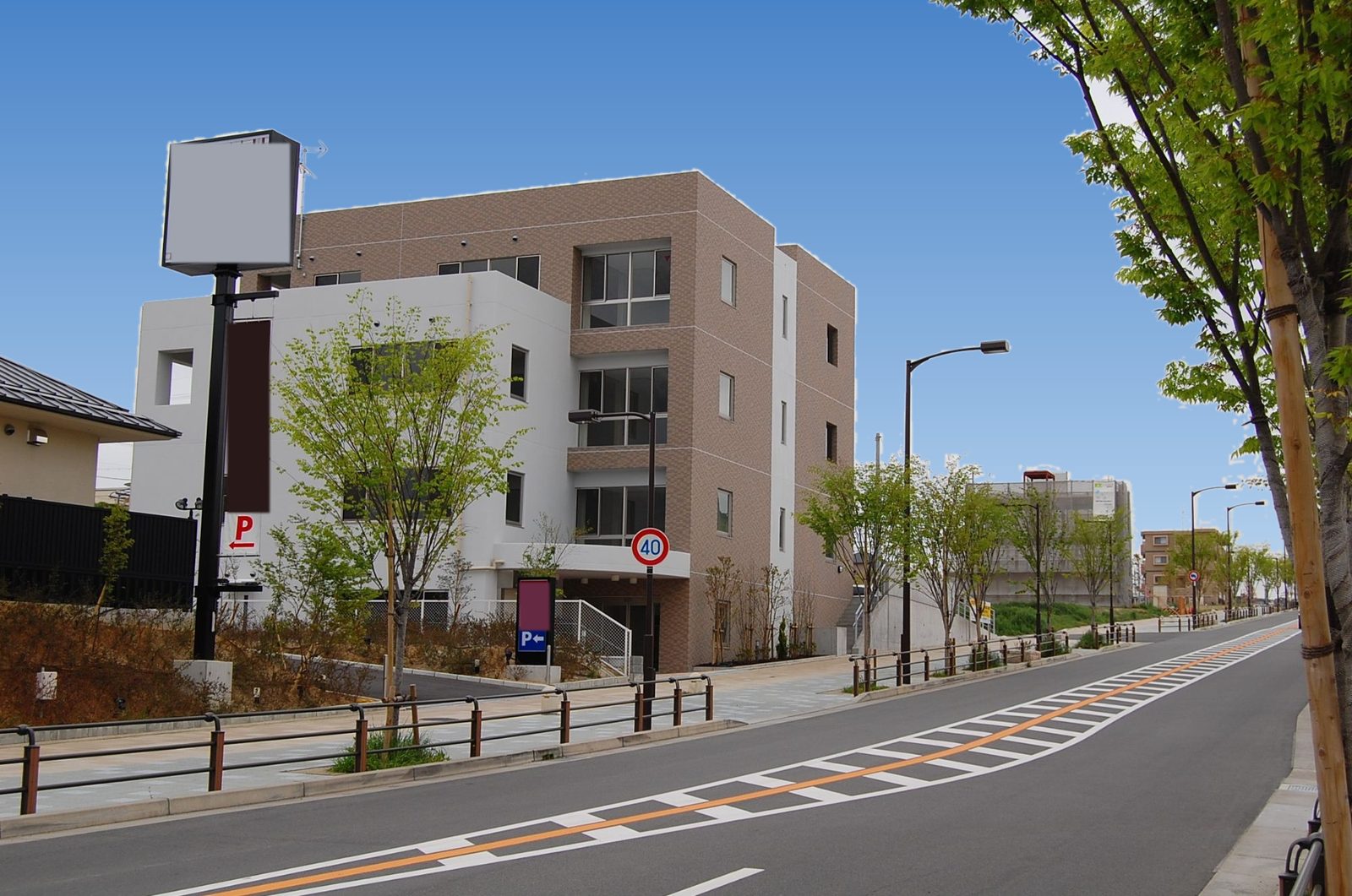 府道沿いに建つテナントビルと並木の歩道