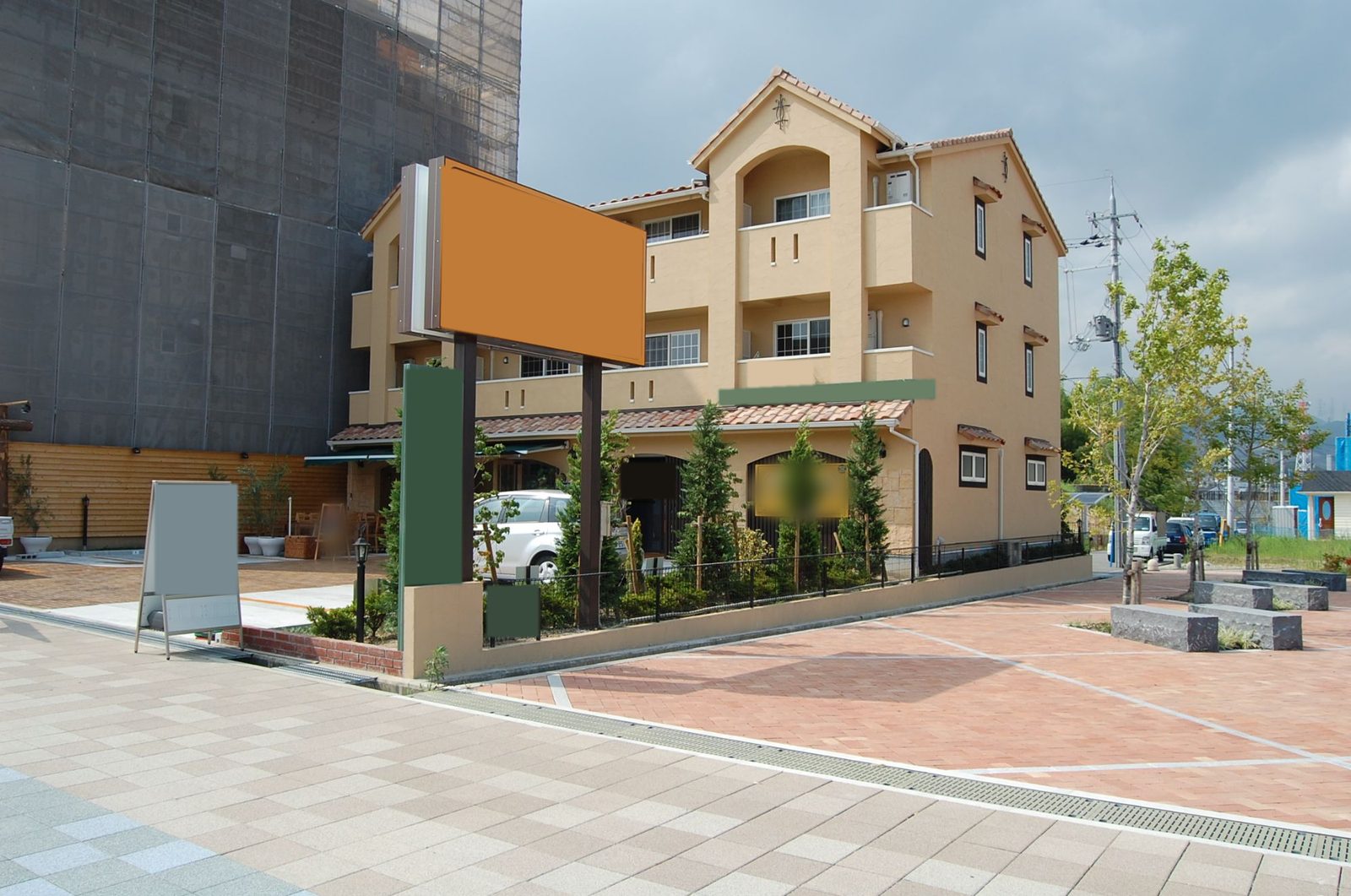 店舗が入居した後の外観。看板と植栽、手前に広い歩道