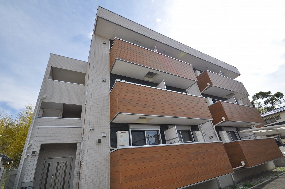 タイル貼りの外壁と木目調のバルコニー、建物の入口